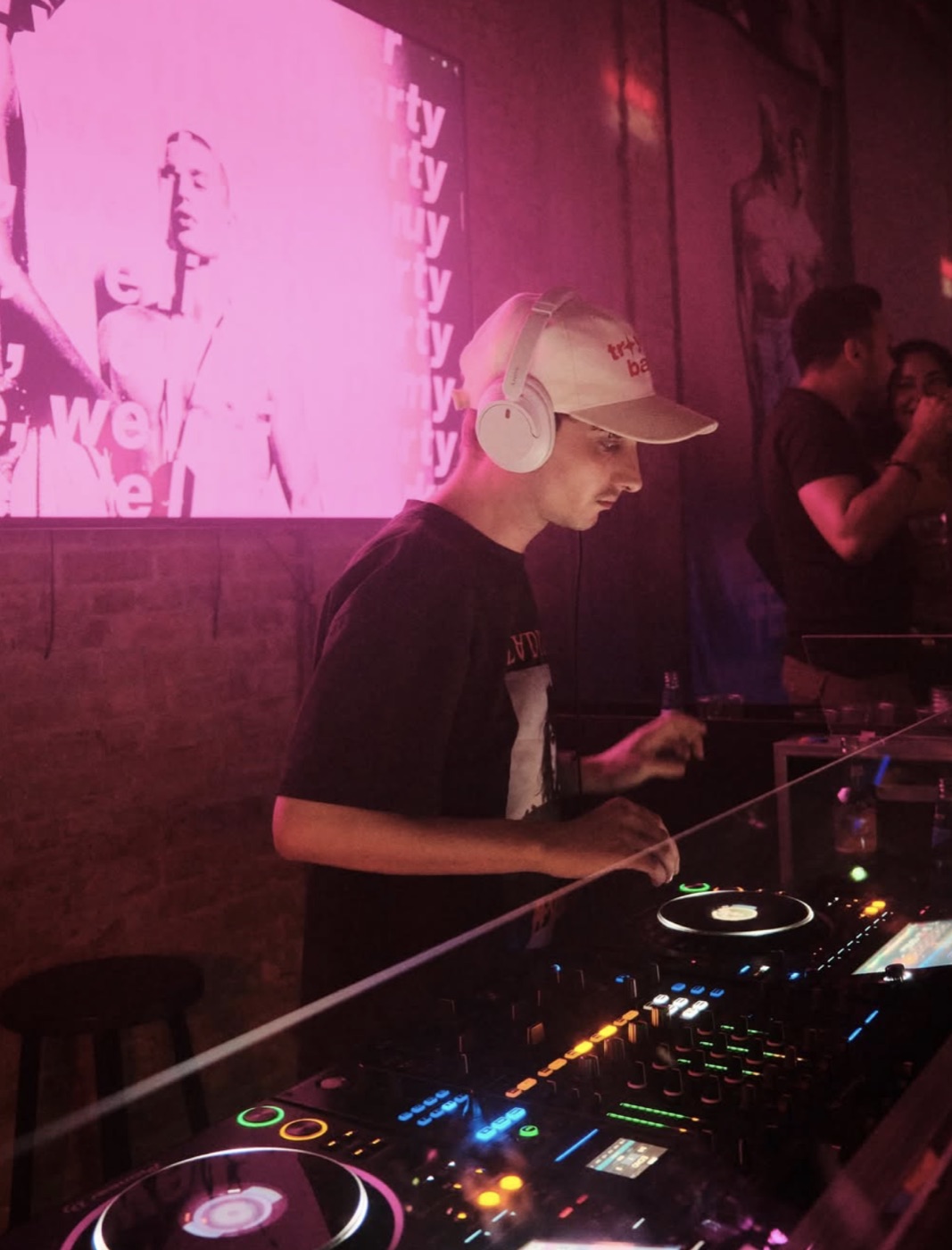 FREY. performing behind the decks in a white cap